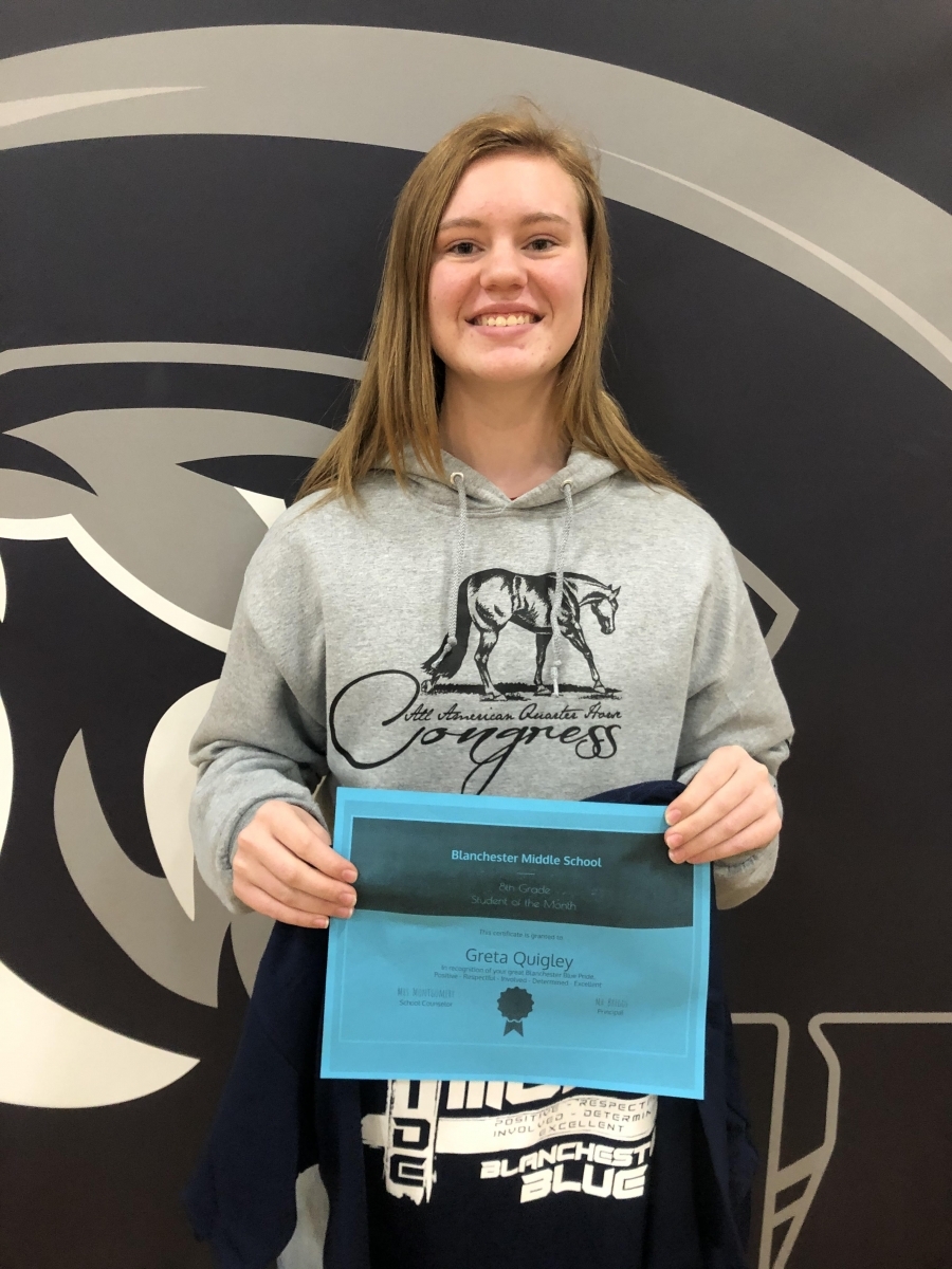 Greta Quigley holding certificate and shirt